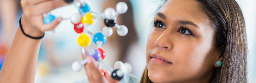 Female student studying model of a molecule